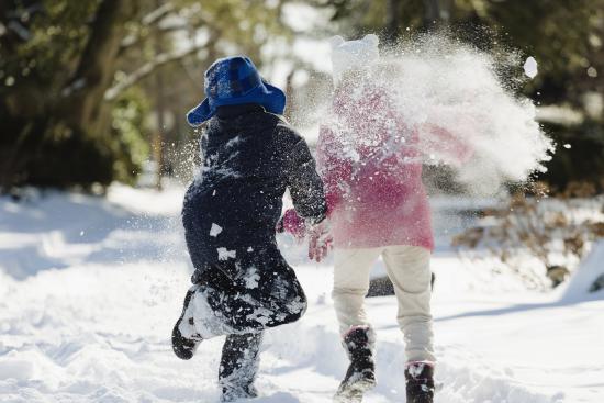 Two children running in snow