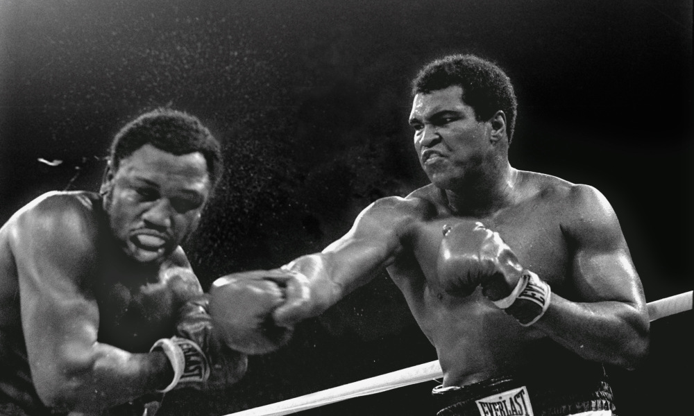 **FILE** Spray flies from the head of challenger Joe Frazier, left, as heavyweight champion Muhammad Ali connects with a right in the ninth round of their title fight in Manila, Philippines, Oct. 1, 1975. Ali won the fight on a decision to retain the title. (AP Photo/Mitsunori Chigita, File) ORG XMIT: NY167